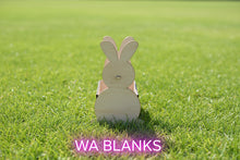 Load image into Gallery viewer, Wooden rabbit decoration on a wooden surface with a textured wall in the background
